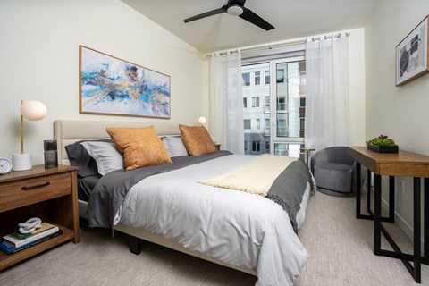 A bedroom with a large bed and a ceiling fan.