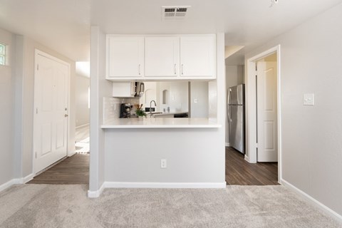 A kitchen area with white cabinets and appliances.