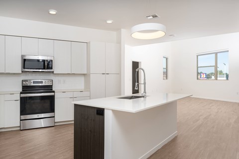A modern kitchen with white cabinets and a wooden island.