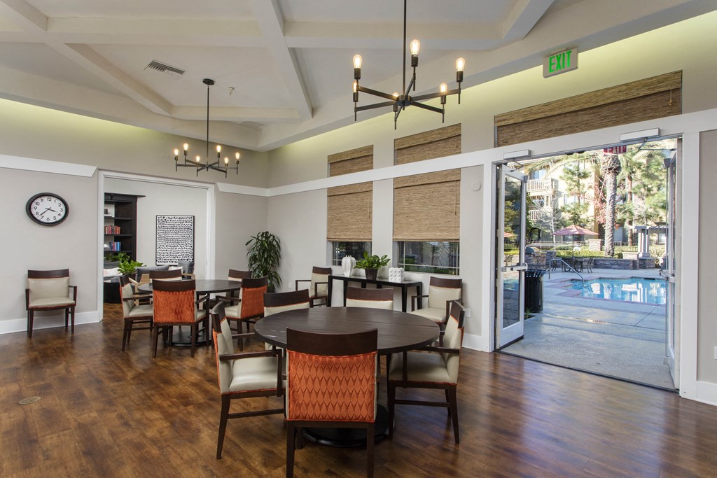 a large room with a large table and chairs and a pool in the background at 55+ Remington at Ladera Ranch, California, 92694