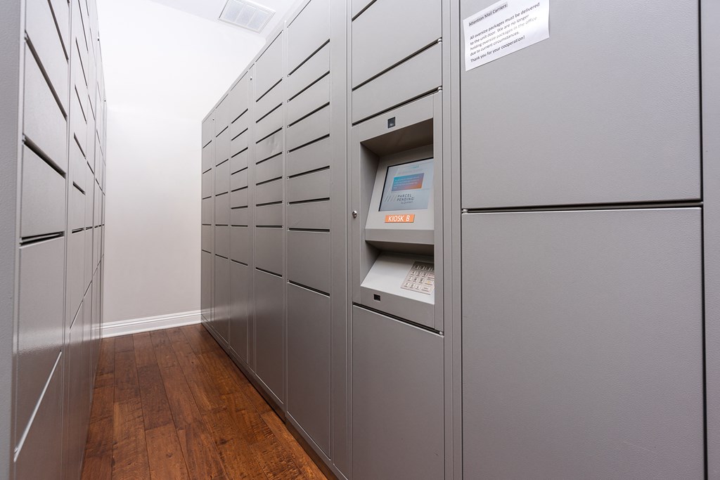 a row of gray lockers in a room with hardwood floors and a white wall