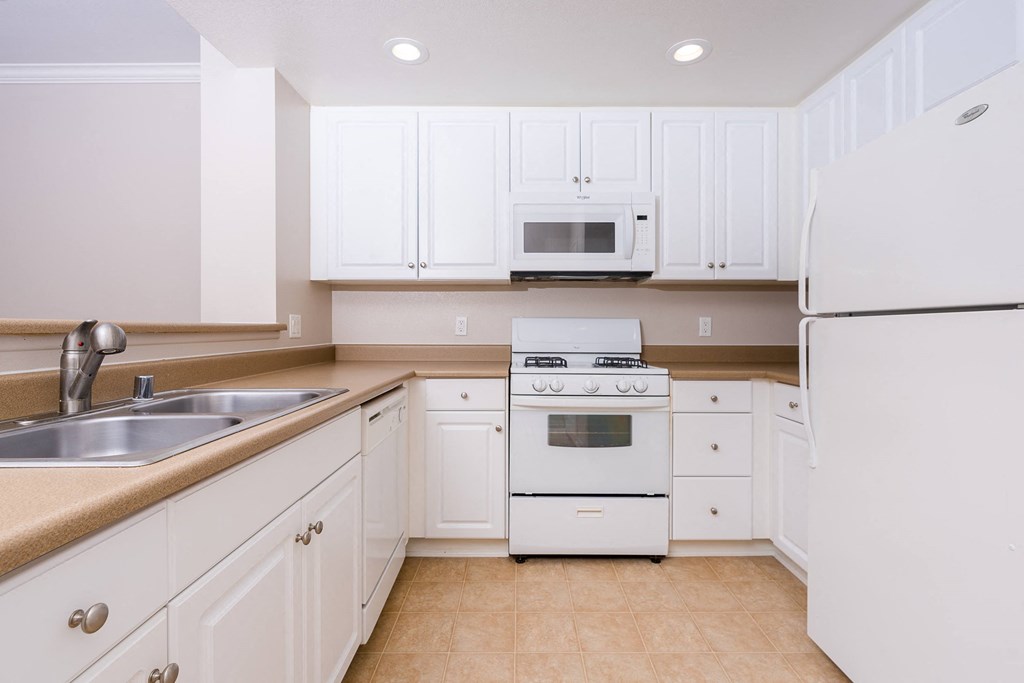a kitchen with white cabinets and white appliances