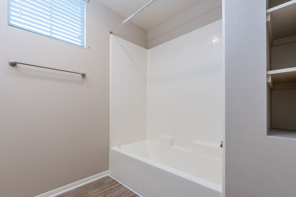 a bathroom with a white tub and a window