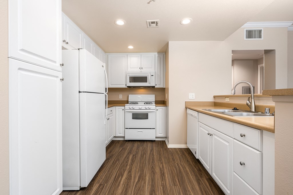 a kitchen with white cabinets and white appliances