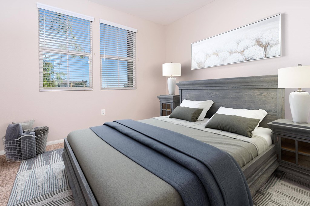 a bedroom with a large bed and two windows