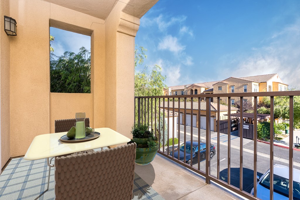 a balcony with a table and chairs and a view of a parking lot