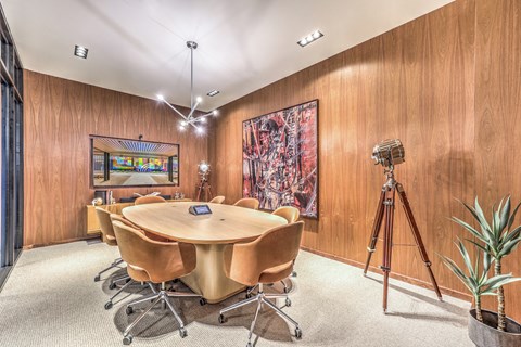 A conference room with a large table surrounded by chairs.