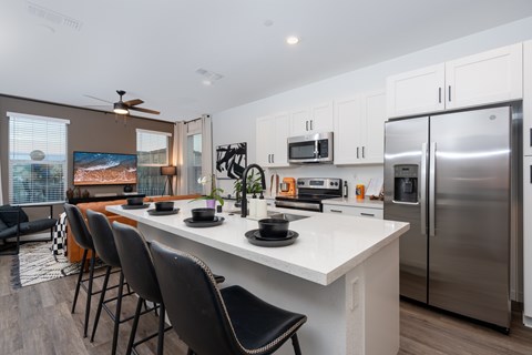 A modern kitchen with a large island and stainless steel appliances.