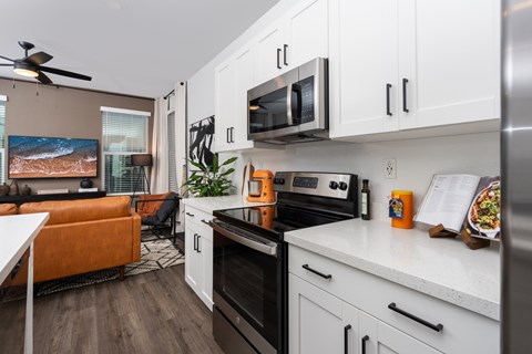 A modern kitchen with a black oven and white cabinets.