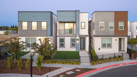 A row of modern houses with a red curb in front.