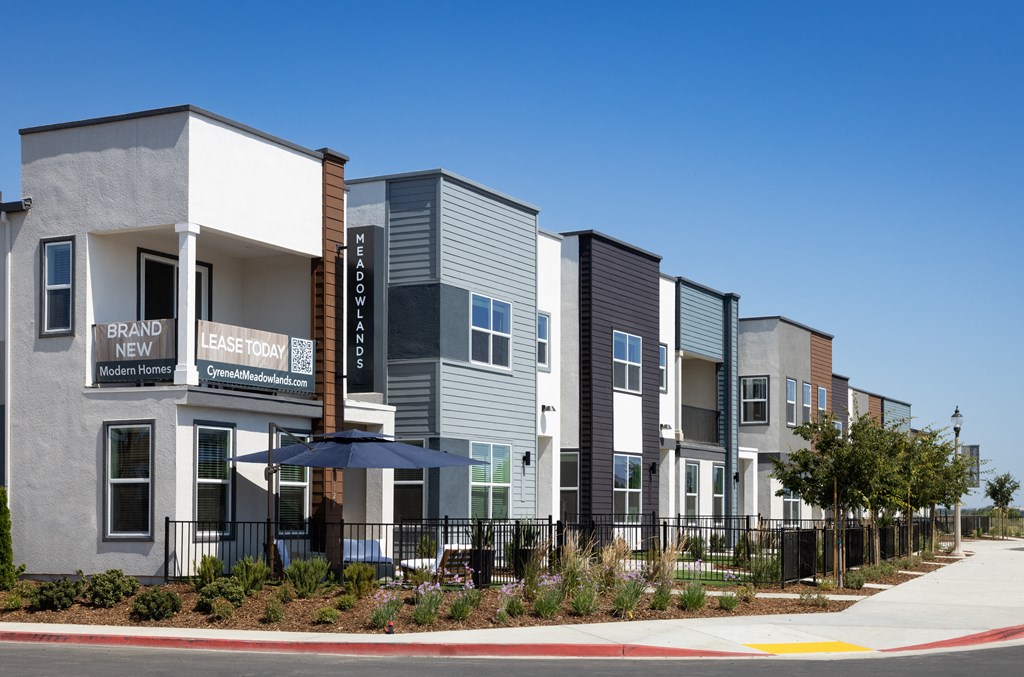 a row of townhomes with a blue sky in the background