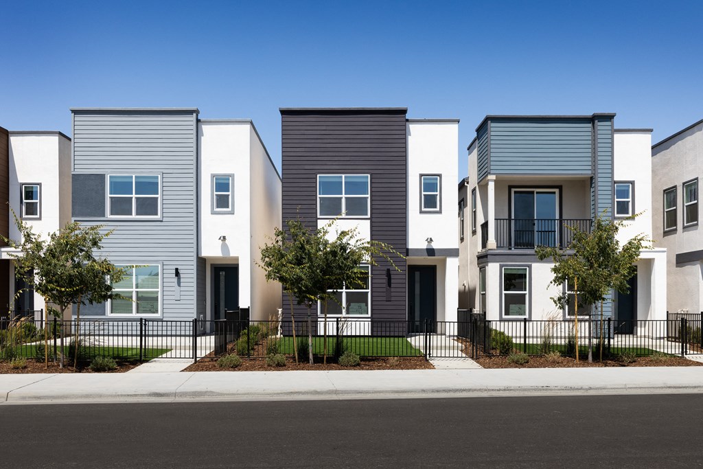 a row of townhomes with a street in front of them