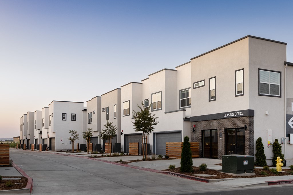 a row of townhomes with a street in front of them