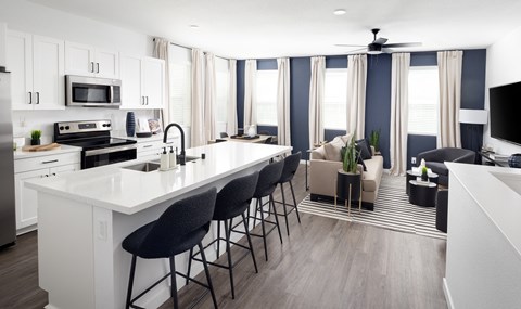 a kitchen and living room with blue and white walls and a white counter top