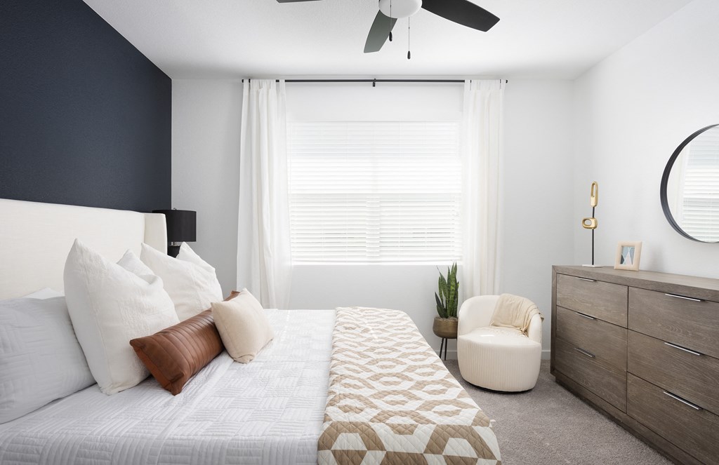 a bedroom with white bedding and a white dresser