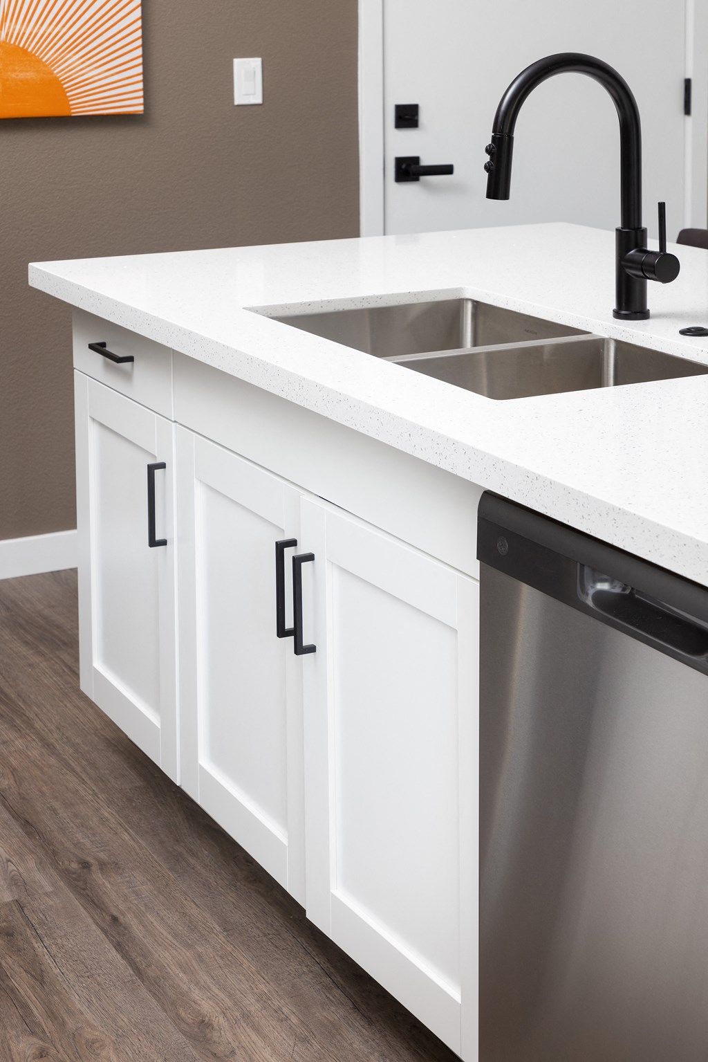 a kitchen with white cabinets and a stainless steel dishwasher