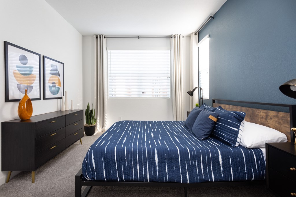 a bedroom with a bed and dresser in a 555 waverly unit