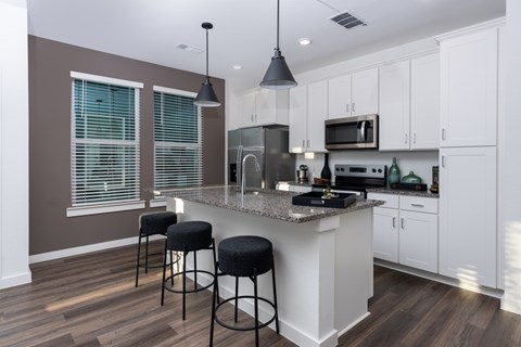 A kitchen with a white counter and brown walls.