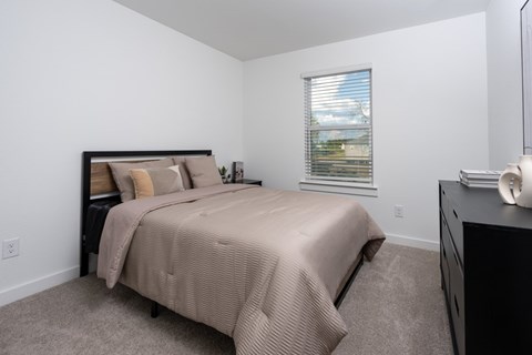 A bedroom with a large bed and a dresser.