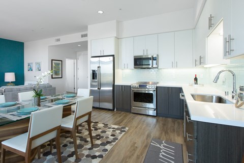 A modern kitchen with a dining table set for two.