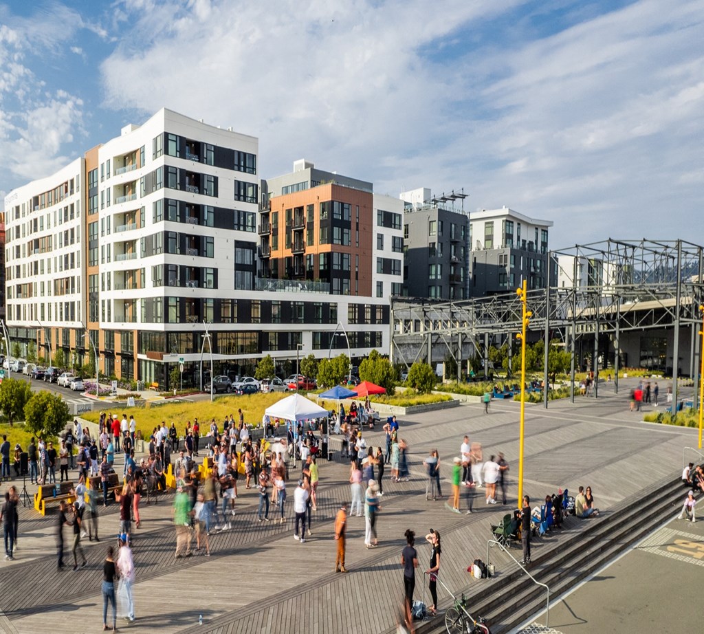 people walking on the boardwalk in front of buildings