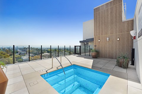 A small pool in a patio with a view of the city at Skyview Sunset Apartments, Los Angeles, California