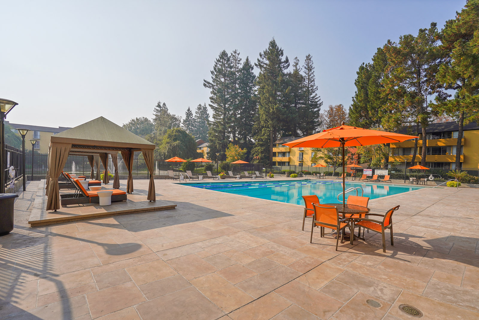 Mountain View Apartments - Americana Apartments - Gated Swimming Pool With Lounge Chairs, Cabanas, Patio Sets, And Maintained Landscaping