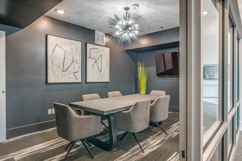 A modern dining room with a large table and chairs.