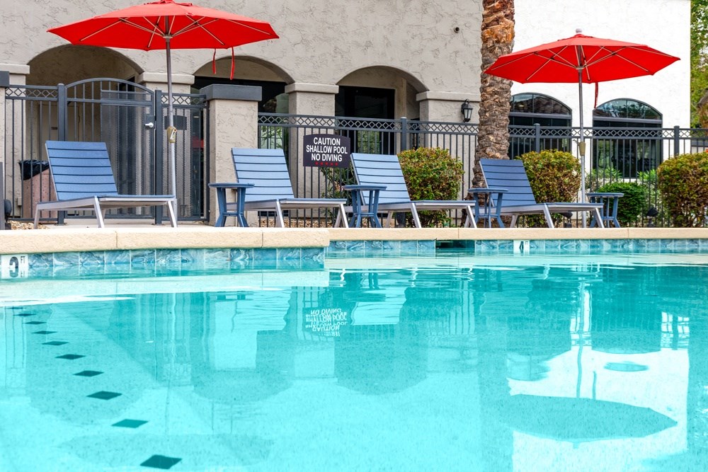 swimming pool with lounge seating and umbrellas