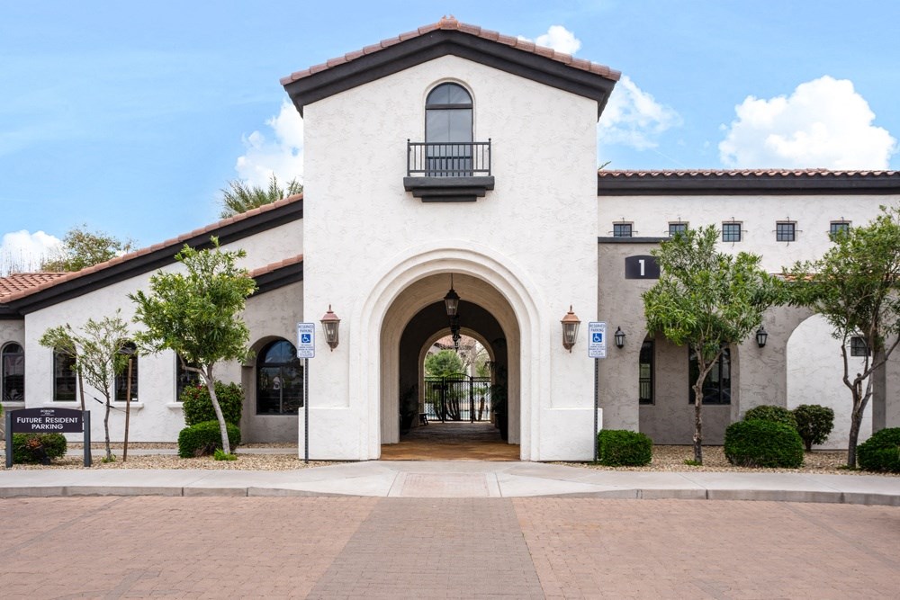 a white building with an arched doorway and a courtyard