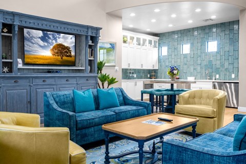 a living room with blue couches and chairs and a tv