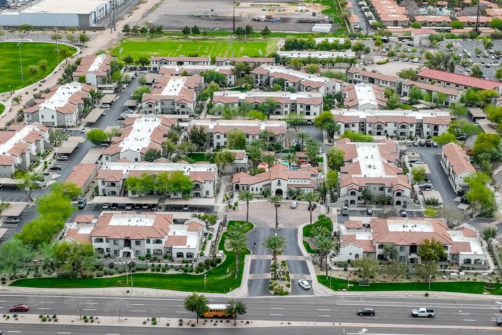 an aerial view of a suburb of a city with cars on the street and houses