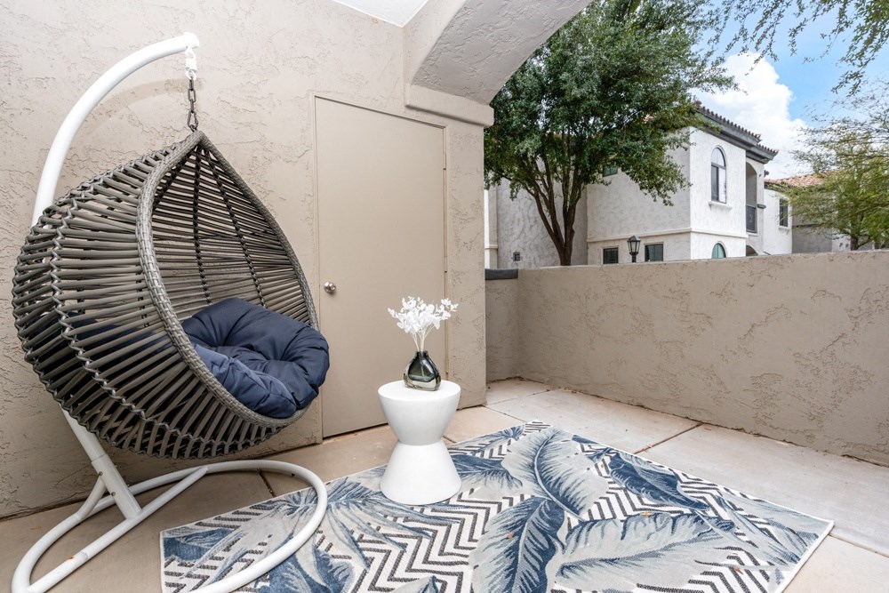 a hammock chair on a patio with a rug