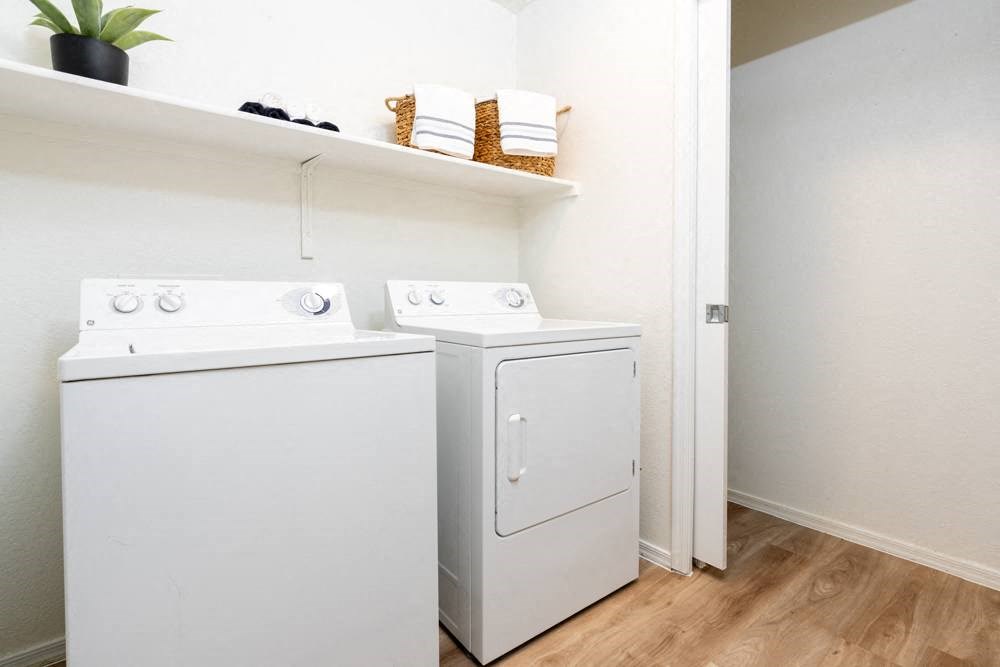 a white washer and dryer in a room with a wood floor