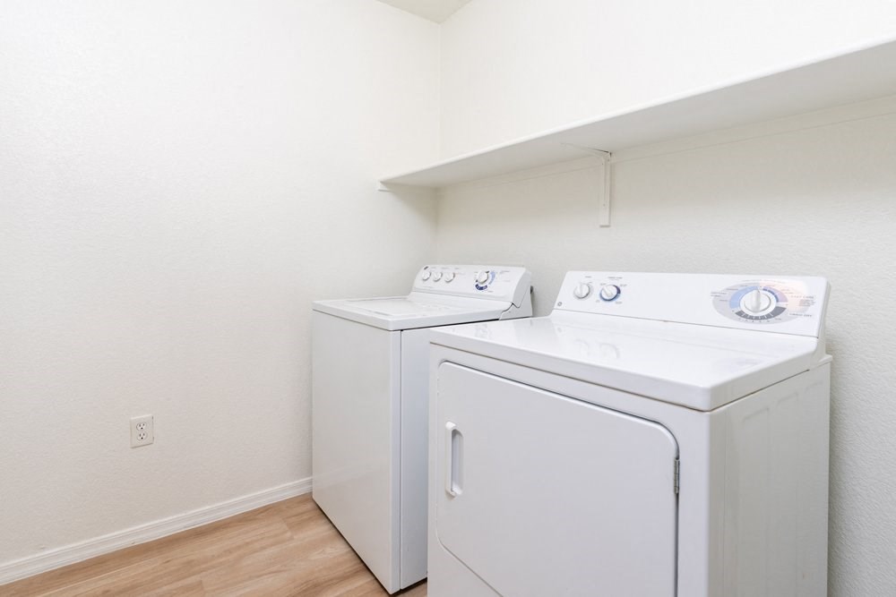a washer and dryer in a room with a wood floor