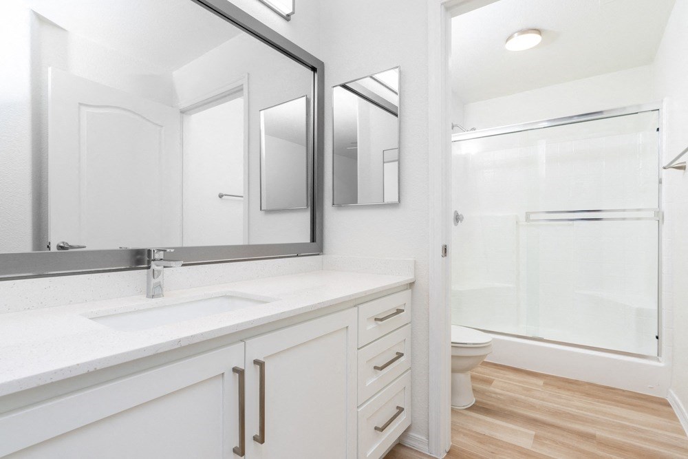 a bathroom with two mirrors and a sink and a toilet
