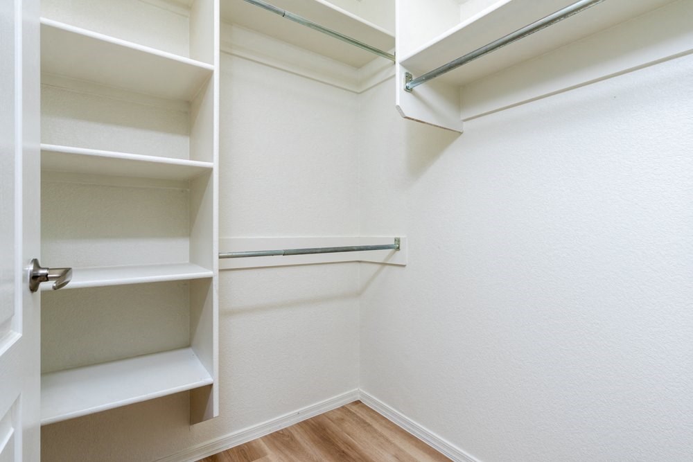 a walk in closet with shelves and a door