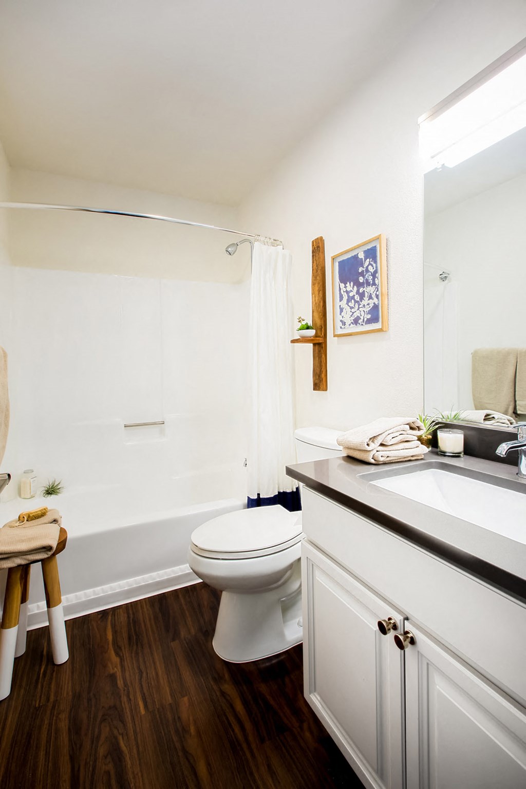 A white toilet in a bathroom with a wooden floor.