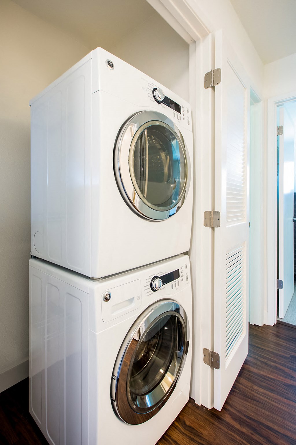 Two white front loading washing machines in a laundry room.