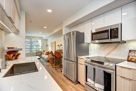 Modern kitchen with marble backsplash and breakfast bar at Eastlake 2851 Apartments, Seattle, Washington