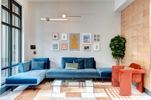 A living room with a blue couch and a red chair.