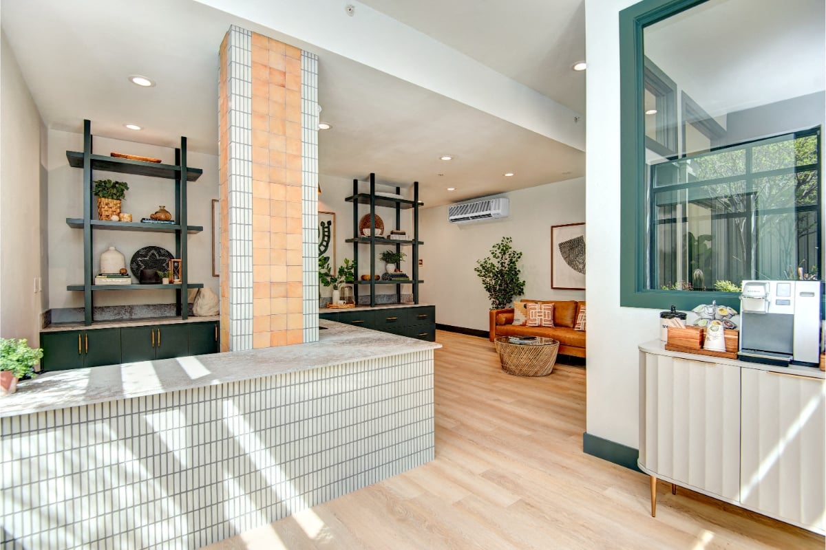 A modern kitchen with a white tile backsplash and wooden floors.