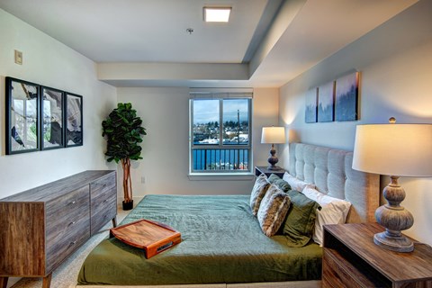 A bedroom with a large bed and a view of the city.