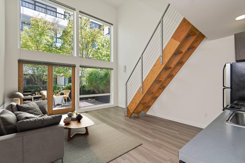 a living room with a couch and a coffee table in front of a large window