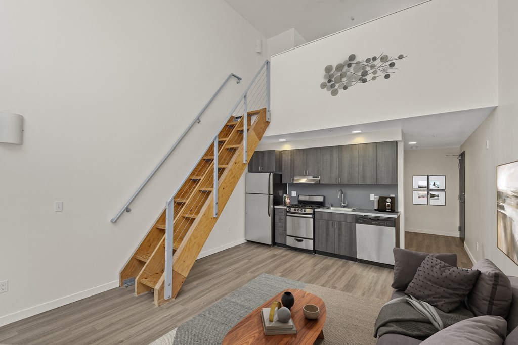 Downtown Seattle Lofts For Rent - Emmons On 3rd - Spacious Loft With Hardwood Flooring, High Ceilings, Staircase, And Access To Kitchen Area.