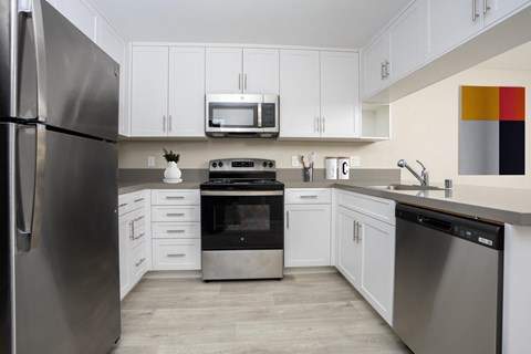 a kitchen with stainless steel appliances and white cabinets