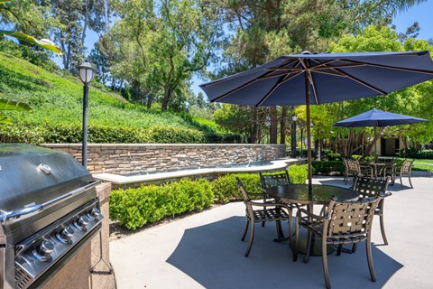a patio with a grill and tables with umbrellas at 55+ FountainGlen Laguna Niguel, Laguna Niguel, CA, 92677