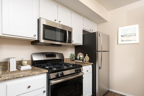 A kitchen with white cabinets and a black stove top oven.