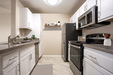 a kitchen with white cabinets and a black stove and refrigerator