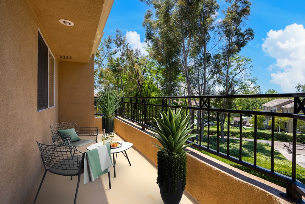 a patio with a table and chairs on a balcony at 55+ FountainGlen Rancho Santa Margarita, Rancho Santa Margarita, CA